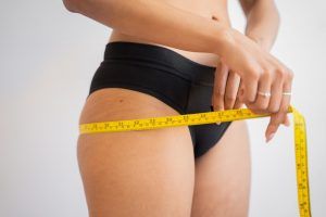 woman with measuring tape around hips
