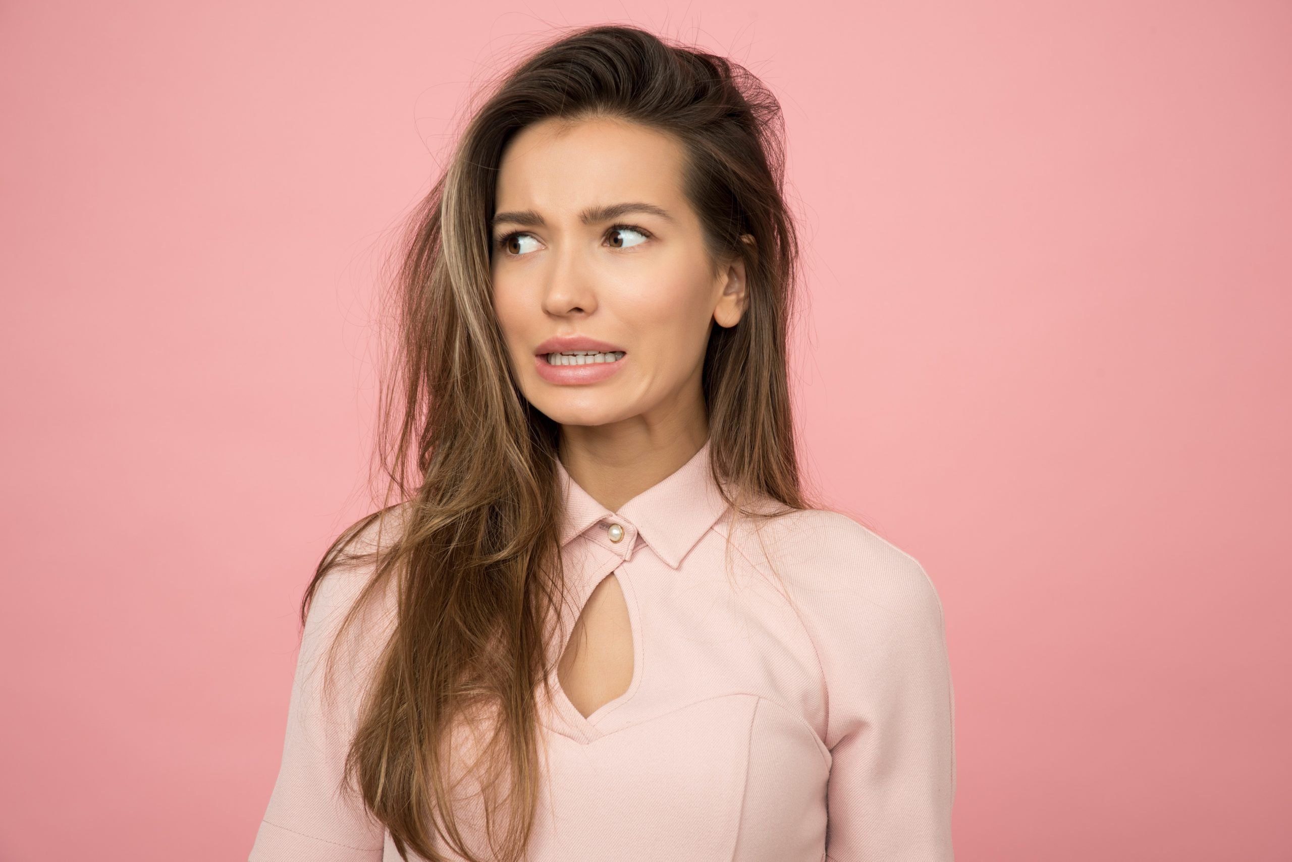 young brunette woman looking awkward about her bad hair transplant